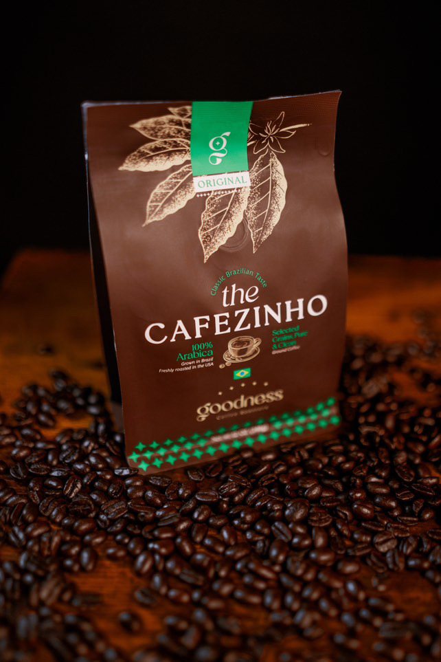 Embalagem do The Cafezinho sobre grãos de café torrados